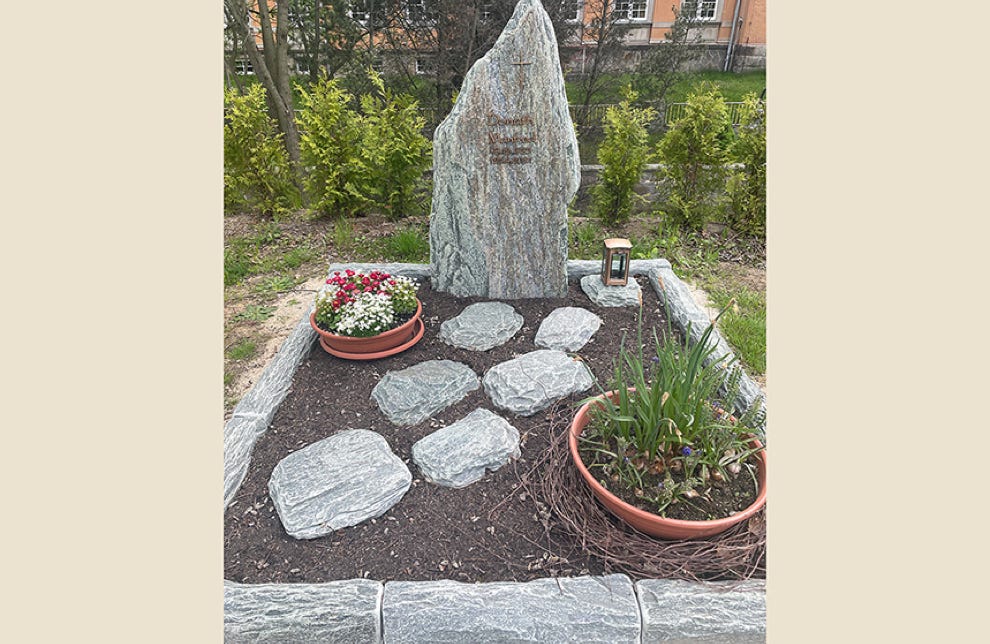 Naturbelassener Grabstein und Grabeinfassung