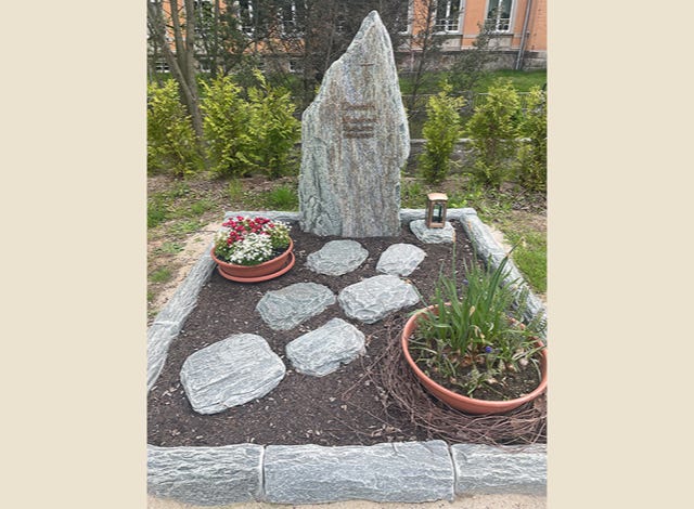 Naturbelassener Grabstein und Grabeinfassung